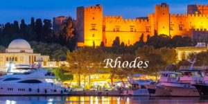 A picture of rhodes at night with the castle in the background.