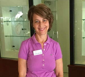 A woman in purple shirt smiling for the camera.