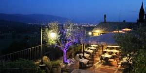 A restaurant with tables and chairs outside at night.