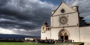 A crowd of people standing outside of an old church.