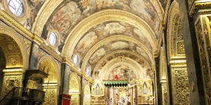 A large cathedral with paintings on the ceiling.