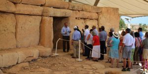 A group of people standing around in front of an entrance.