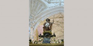 A statue of a man sitting on top of a chair.