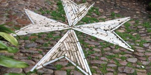 A star made out of wood sticks and nails.