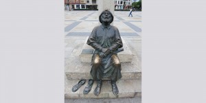 A statue of a person sitting on steps.