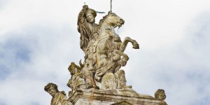 A statue of a man on horseback with other statues.