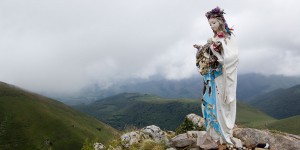 A statue of jesus and mary on the top of a mountain.