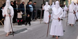 Men dressed in white carry crosses and drag chains as part of the deep symbolism of the ceremonies in Malta celebrating the Passion and Easter.