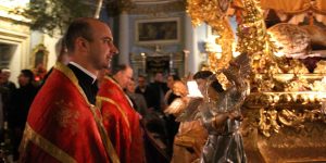 A priest dressed in red and gold robes as part of the Easter ceremony in Malta