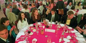 A group of people sitting at a table with wine glasses.