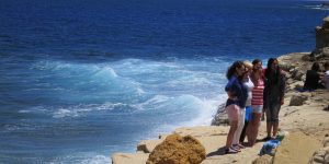 Mission students standing on a beach near the ocean in Malta.