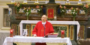 A priest is standing at the altar of a church.