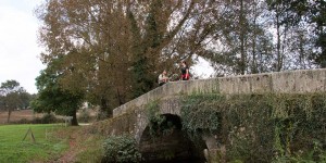 A couple of people standing on top of a bridge.