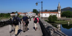 A group of people walking across a bridge.