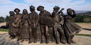 A group of statues that are standing in the sand.