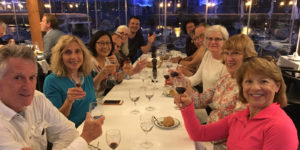 A group of people sitting at a table with wine glasses.