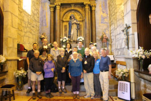 A group of people standing in front of a statue.