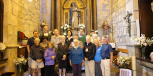 A group of people standing in front of a statue.