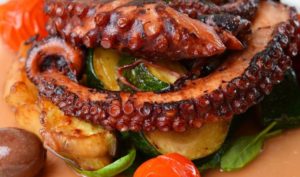 A close up of an octopus on some vegetables