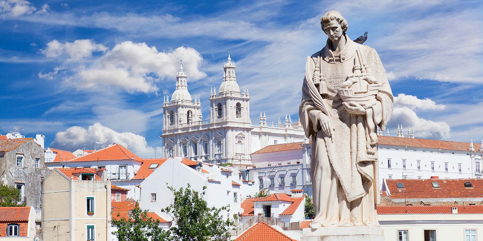 A statue of jesus stands in front of the church.