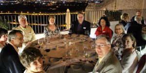 A group of people sitting around a table with wine glasses.