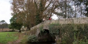 A couple of people are sitting on the bridge