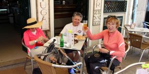 Three women sitting at a table with drinks.