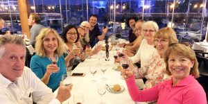 A group of people sitting at a table with wine glasses.