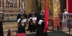 A group of men in black robes holding flags.