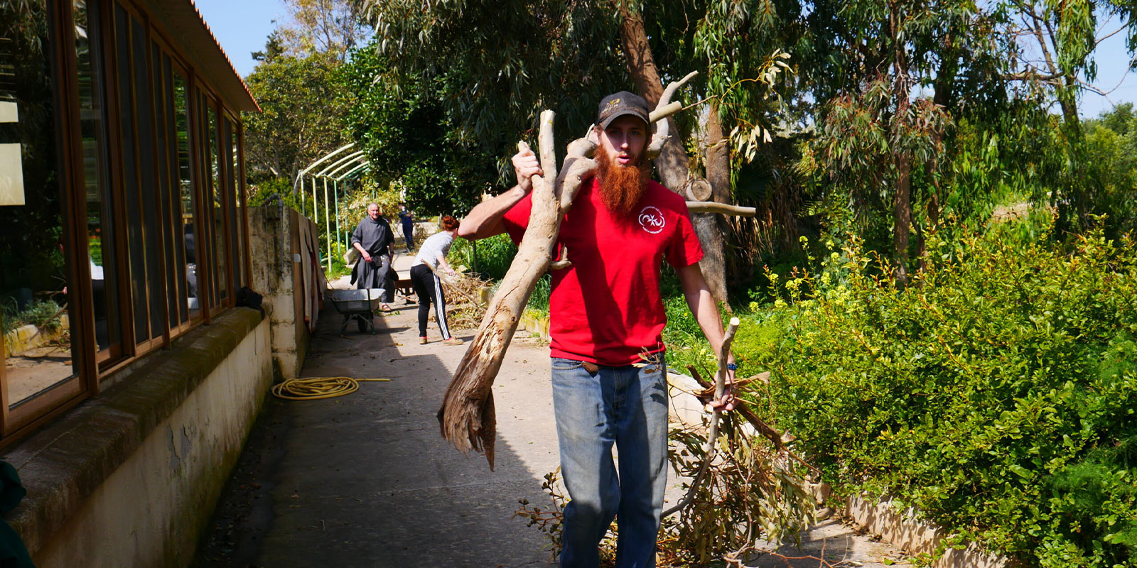 Student clearing tree branch and brush on his MedSeas mission trip.