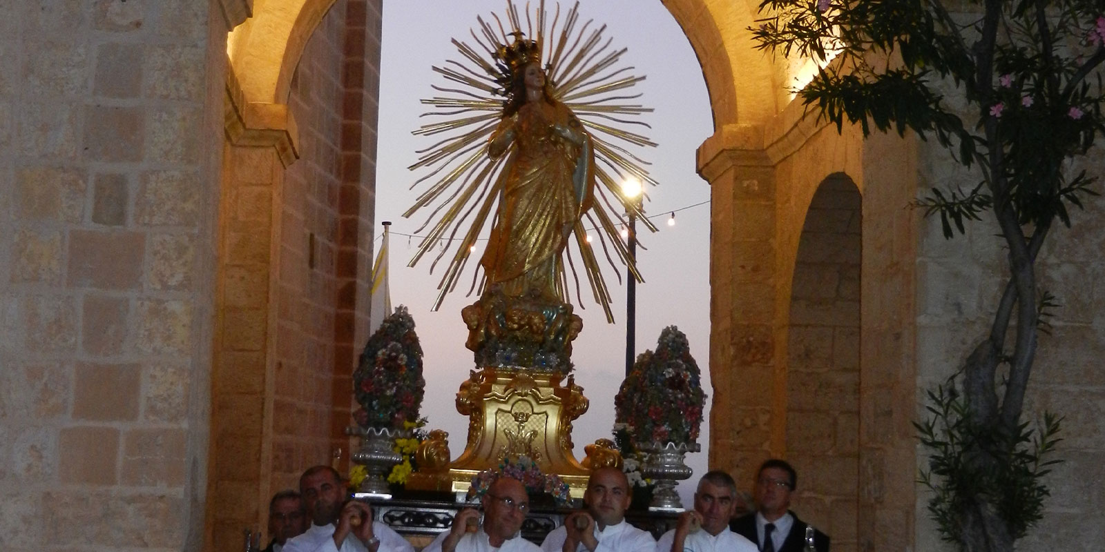 An Our Lady of Victory statue is carried under an arch in Malta